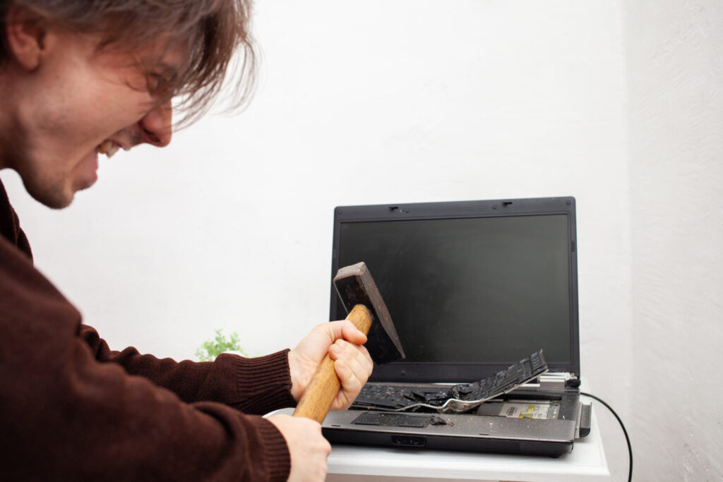 man smashing computer